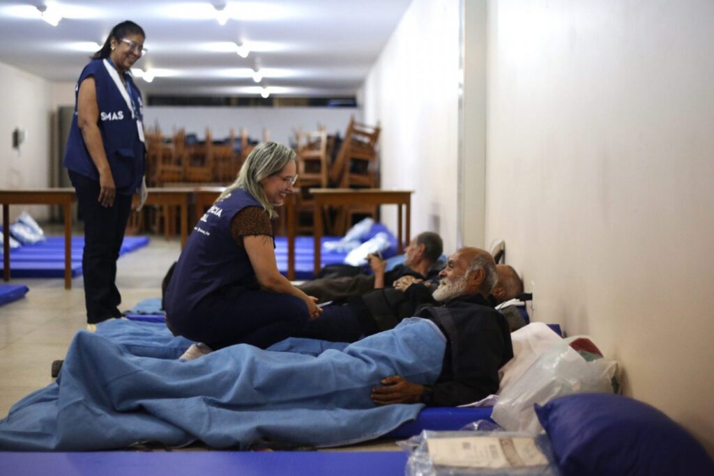 Pessoas recebendo assistência em abrigo temporário no Rio de Janeiro durante o inverno