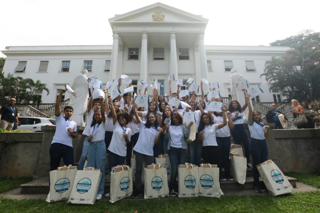 Alunos das escolas municipais do Rio de Janeiro sorrindo e segurando seus novos notebooks, premiados no concurso Jovem Cidadão Carioca.