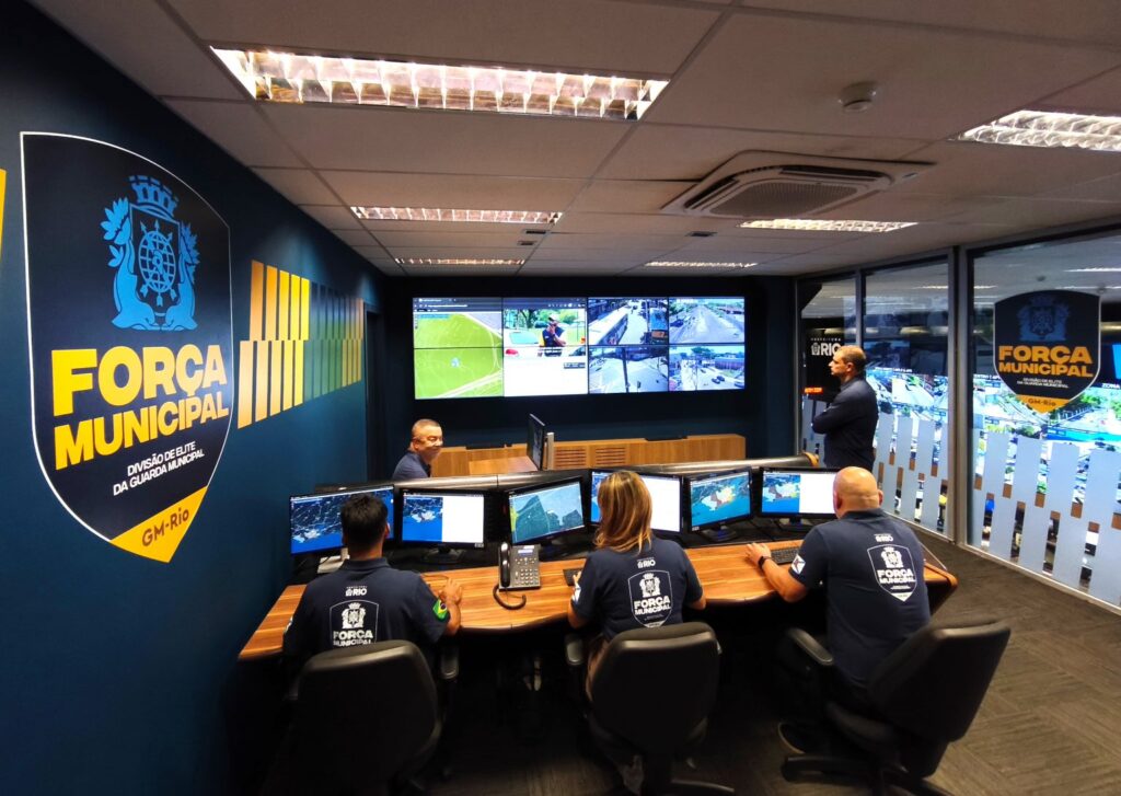 Sala de monitoramento da Força Municipal da GM-Rio com agentes observando telas.