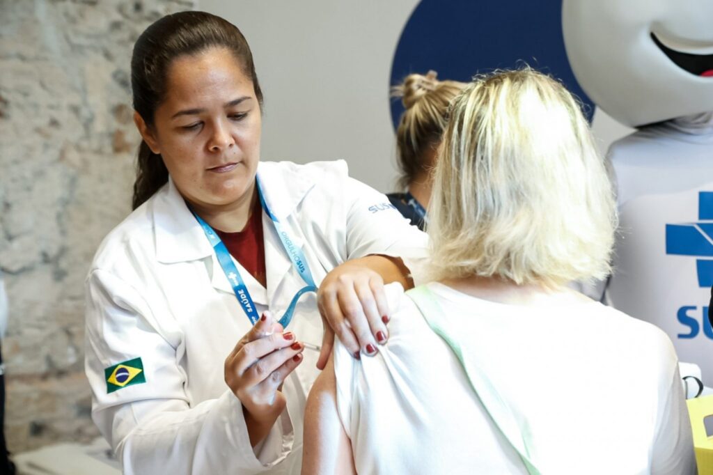 Profissional de saúde aplicando vacina contra a gripe em um paciente no Rio de Janeiro.