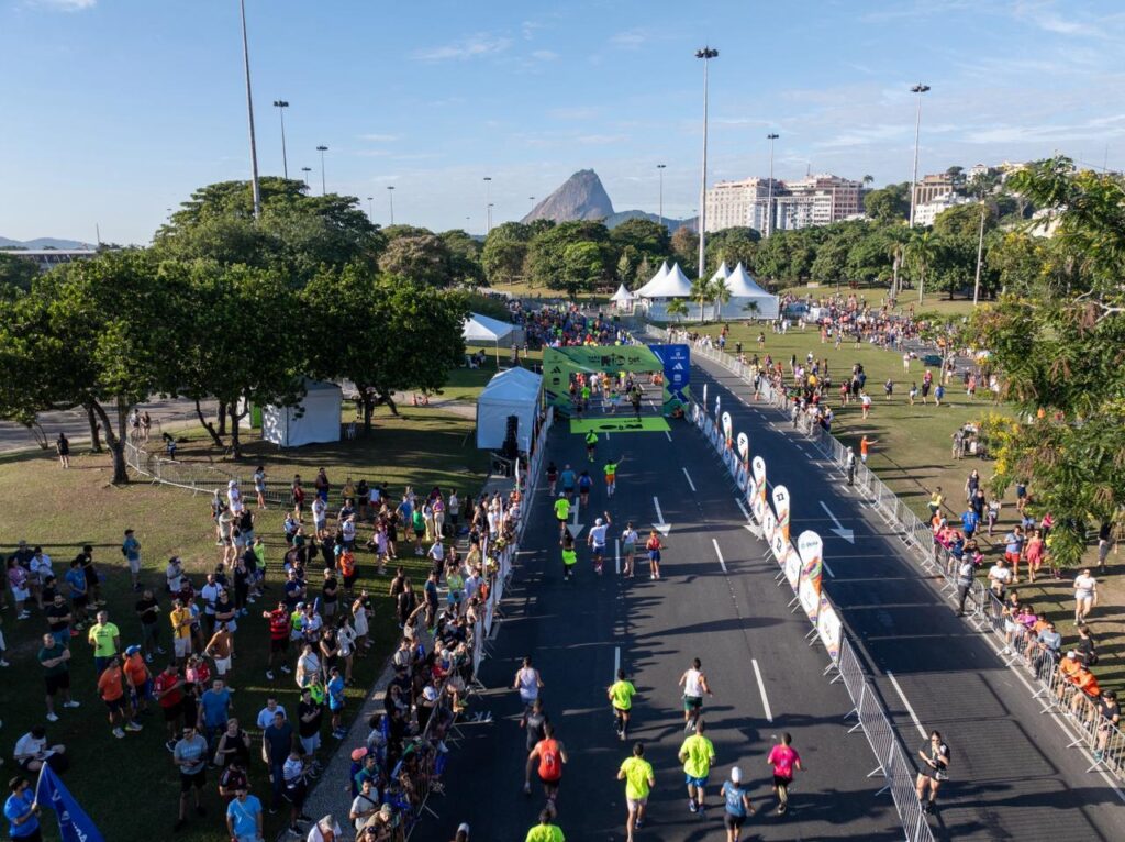 Corredores largando na Maratona do Rio 2026 com vista para as paisagens do Rio de Janeiro.