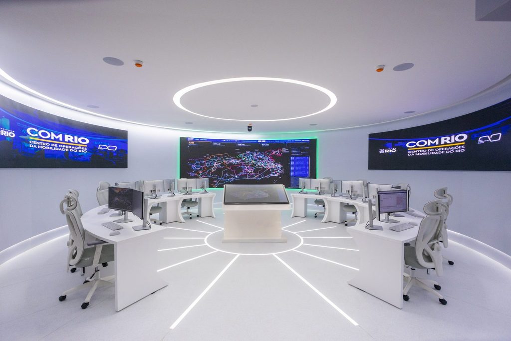 Sala de monitoramento do Centro de Operações de Mobilidade Rio (COM RIO) com painéis de LED.